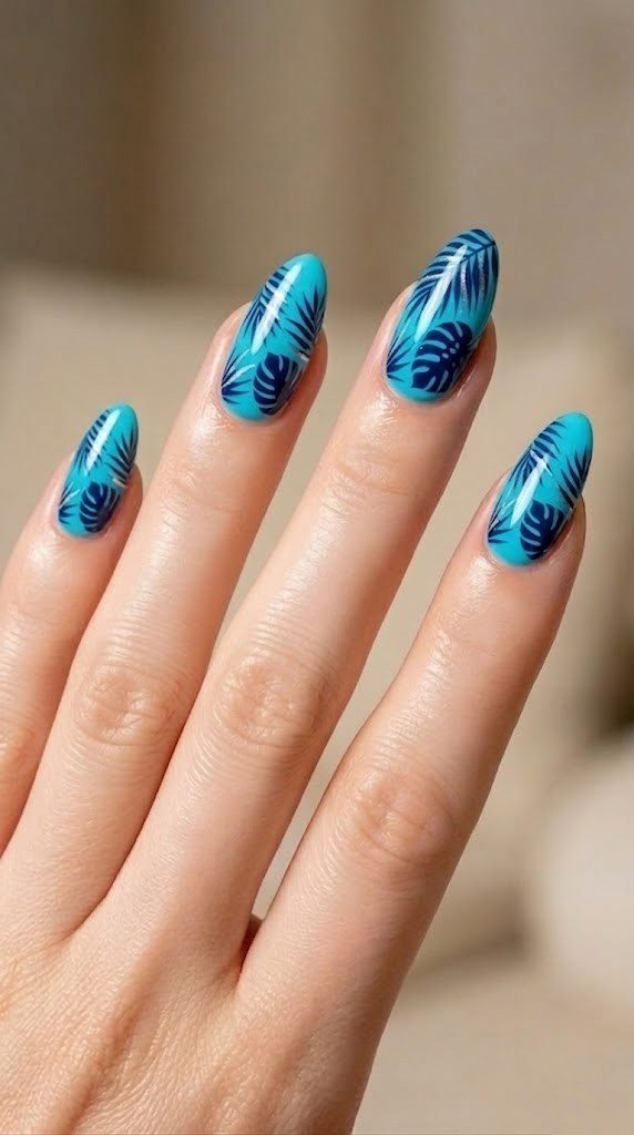 Bright turquoise almond nails with dark navy blue monstera leaves and palm frond detail