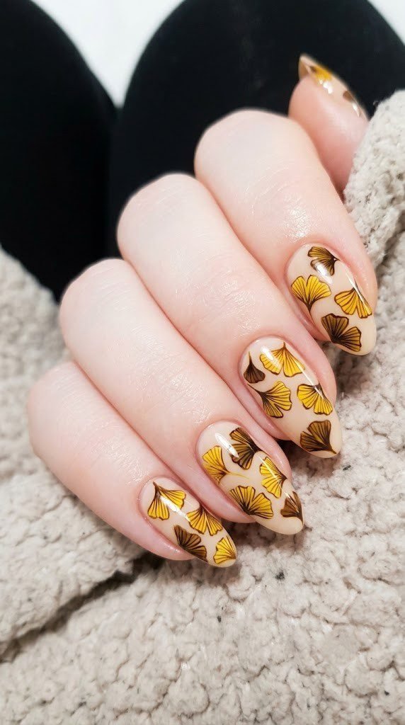 long almond nails with mustard yellow and ochre ginkgo leaf fan art on nude base
