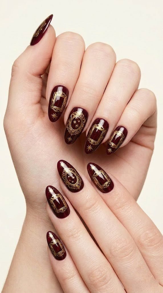 long almond nails with ornate golden baroque frames on deep cabernet wine red gel base