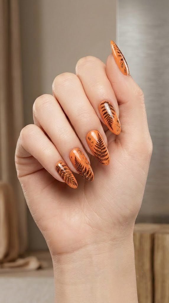 Papaya orange fall nail ideas with drying fern and bronze leaf art