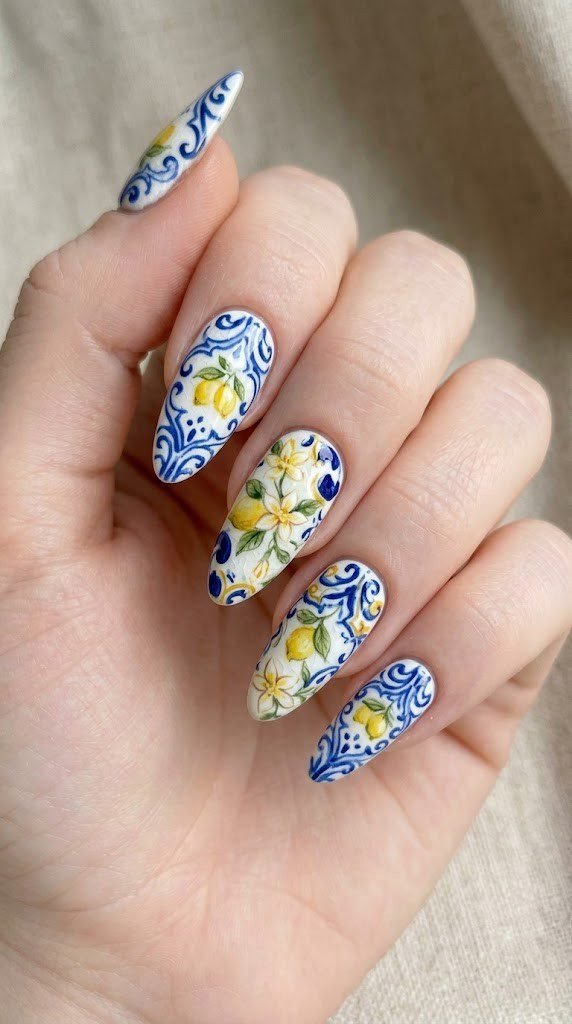 White almond nails with cobalt blue and yellow majolica tile pattern and hand-painted lemon motifs