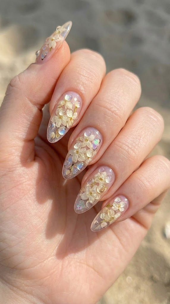 Clear jelly almond nails with pressed cream hydrangea petals aurora glitter and 3D water droplets