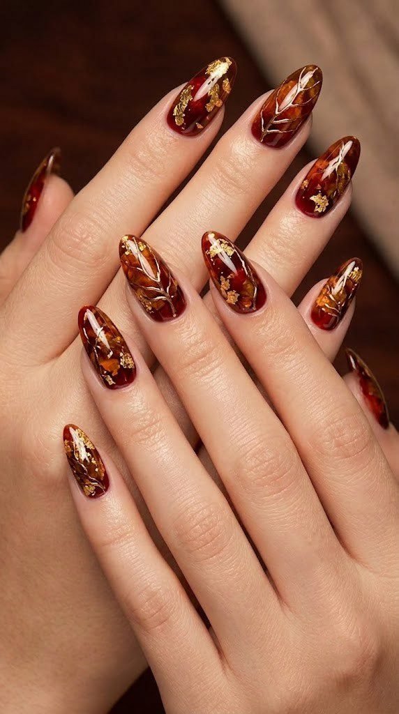 Crimson and amber jelly almond nails veined with liquid bronze chrome