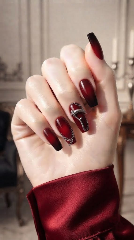 Blood red ombre coffin nails with a sculpted silver scythe charm accent