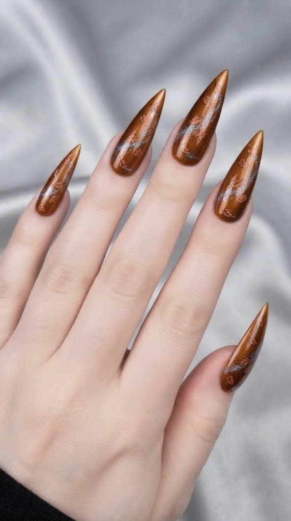 chrome stiletto nails in amber bronze with falling leaf detail