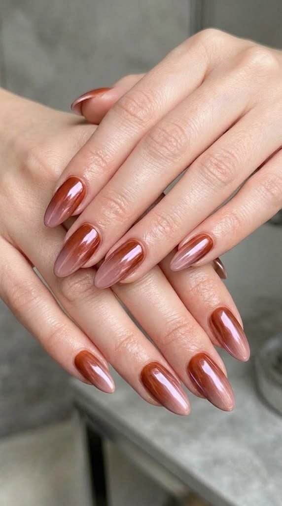 Terracotta to rose ombre almond nails sealed under an amethyst chrome glaze