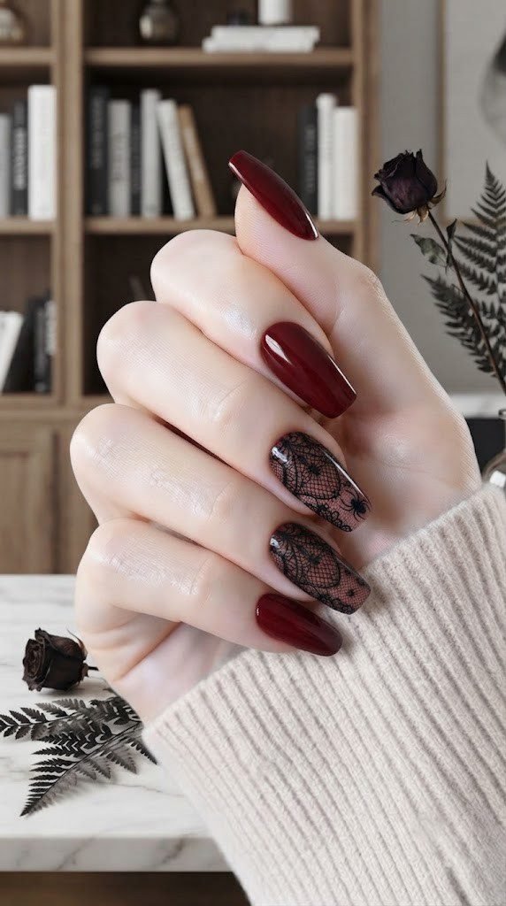 Dark red coffin nails with gothic lace detailing and a tiny spider silhouette