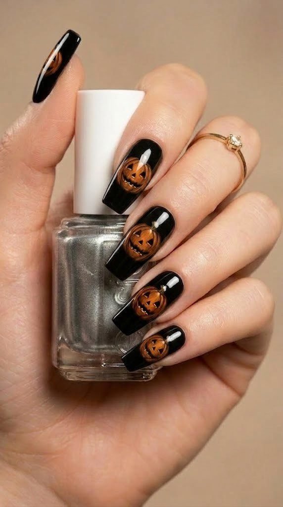 Bold Halloween square nails with a glowing amber pumpkin face on black