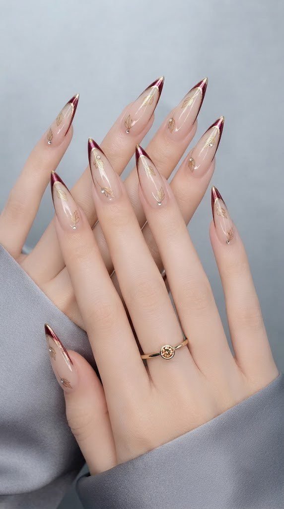 fall French tip nails in burgundy gold with falling leaf detail