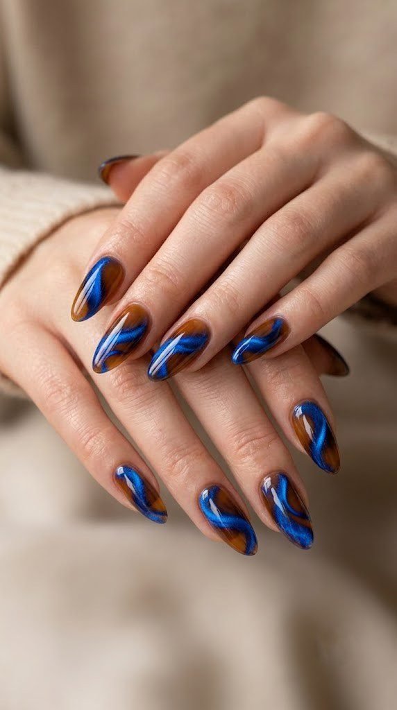 Molten caramel nails swirled with sapphire blue, unexpected fall nail colors