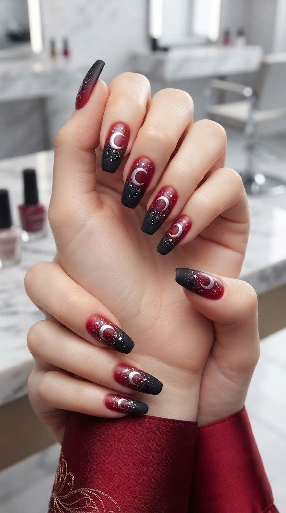Red to black ombre nails with a glossy silver crescent moon accent