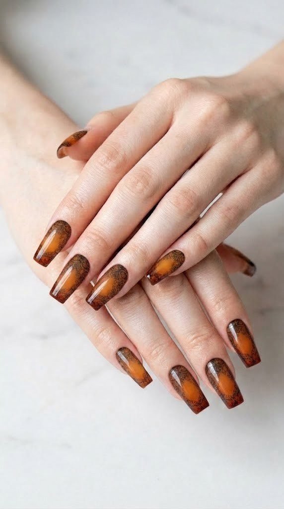 Amber to burnt orange gradient nails with sheer black lace stamping detail