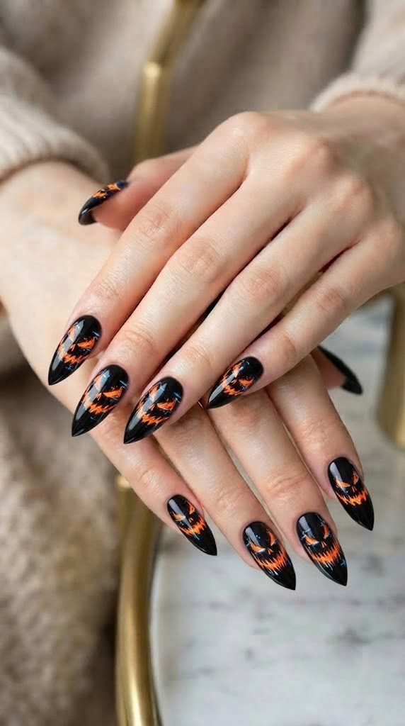 Black and orange halloween nails with a glitch-art pumpkin on stiletto tips