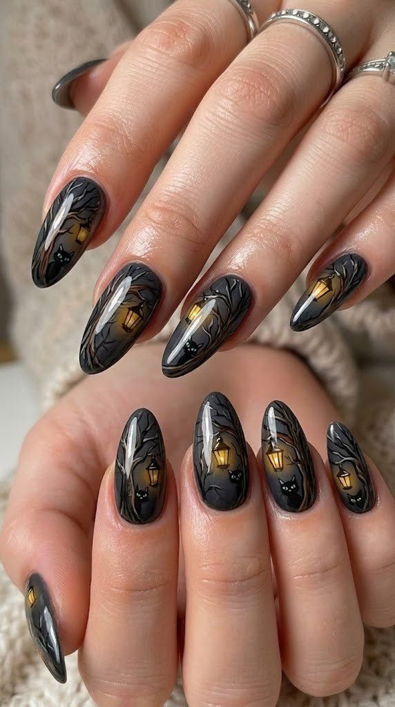 Charcoal and mustard nail art featuring skeletal trees, glowing lanterns, and black cats