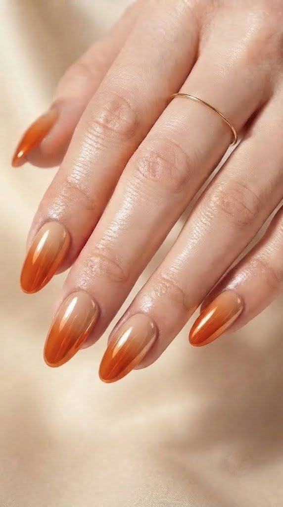Chrome finish nails fading from burnt persimmon into creamy glazed nude