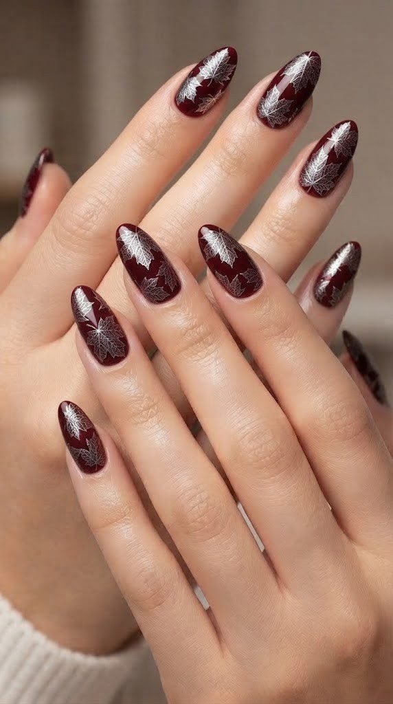 Claret nail design with silver chrome maple leaf stamping