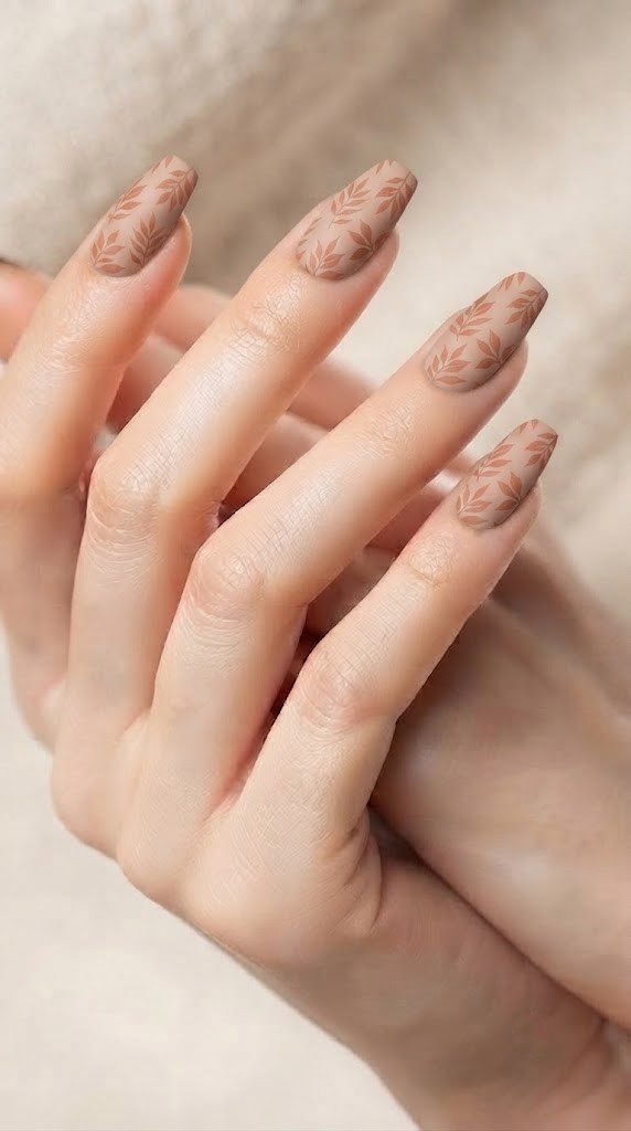 Clay terracotta autumn nail design with pressed leaf silhouettes