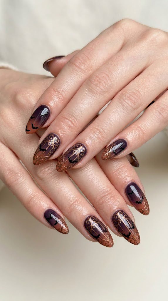 Eggplant to terracotta ombre nails with bronze filigree and tiny bat silhouettes