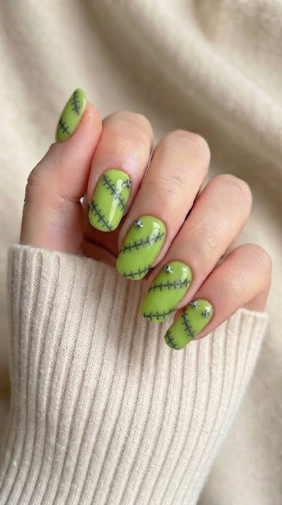 Lime-green Halloween nail art with stitch scars and silver bolts