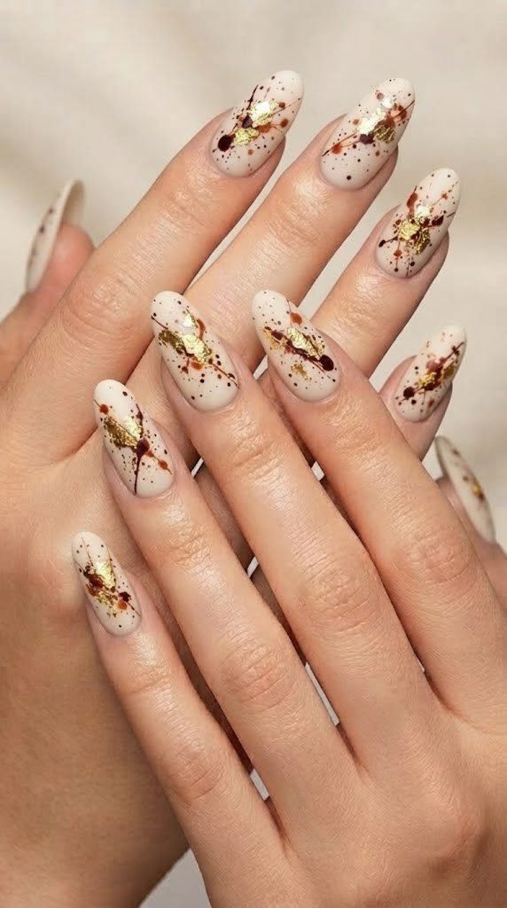 Ivory matte fall nail design with mahogany splatter and gold leaf flecks