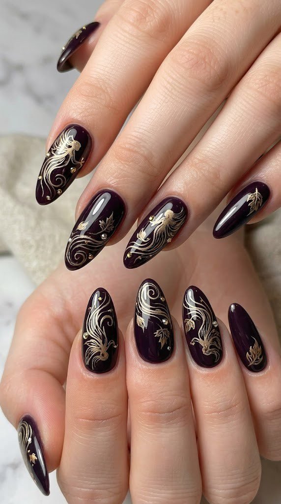 Deep midnight-plum nail art with champagne-gold spirit swirls and gemstone accents