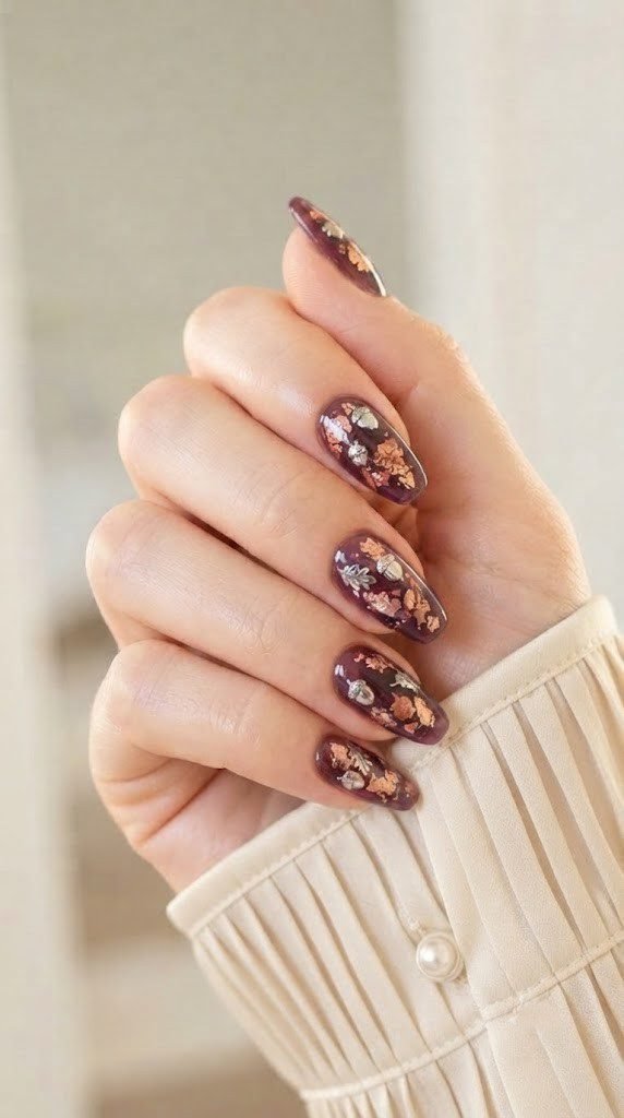 Plum glass gel autumn nails with copper flakes and chrome acorns