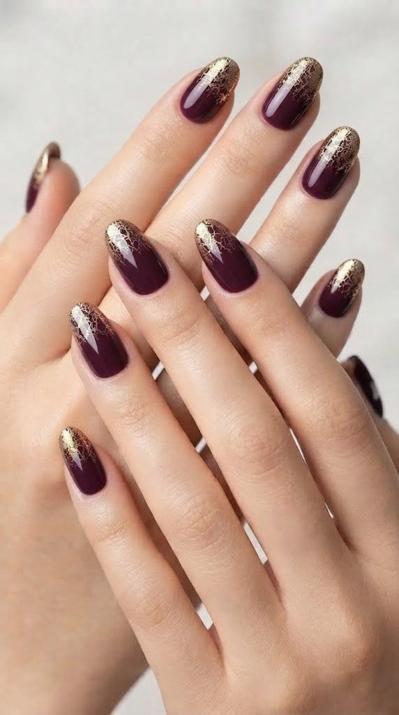 Wine red plum nails with a gold foil crackle tip, elegant September nails