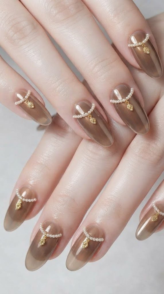 Oval fall nail design with smoky topaz chrome and a draped pearl strand