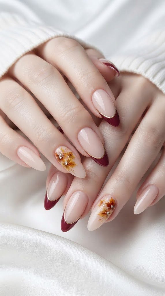 Almond fall nail design with wine French tip and gold maple flower accent